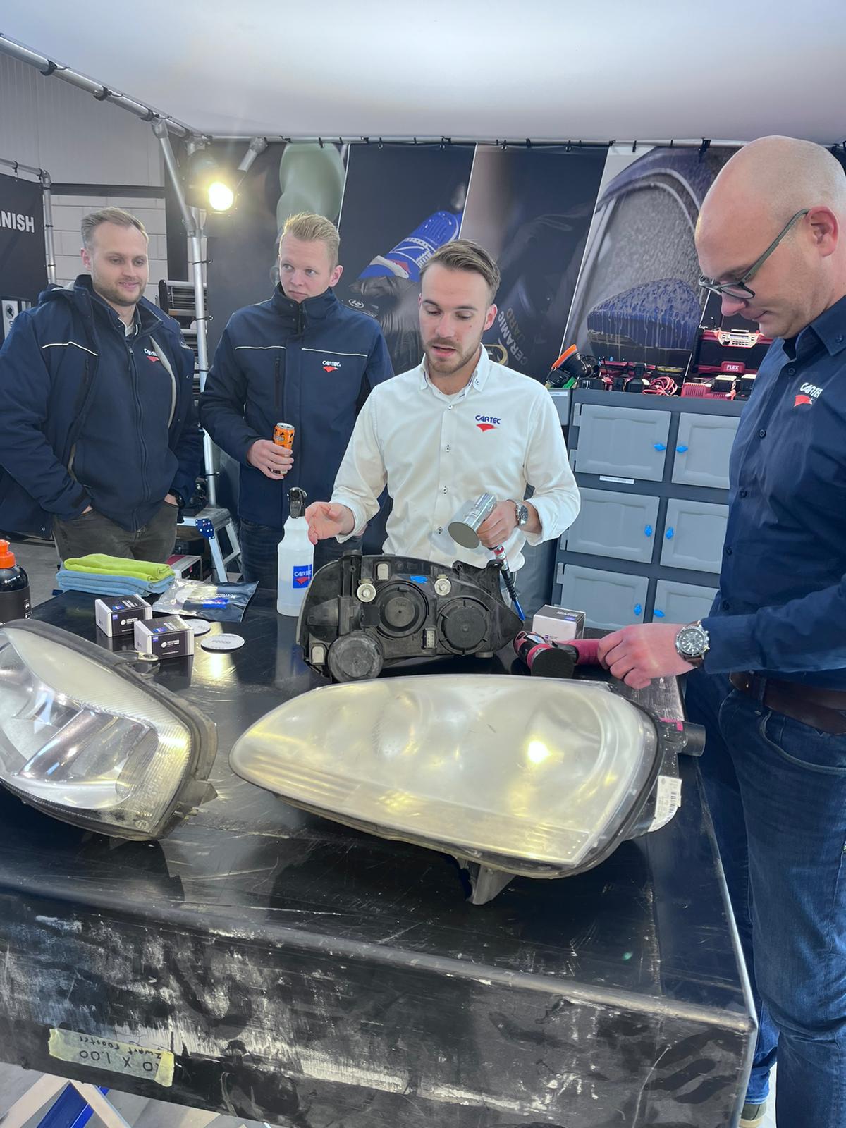 Participants observant un exercice technique sur des optiques automobiles chez Cartec à Amsterdam