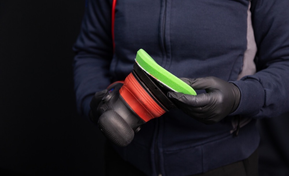 Pose d’un Refinish Unipad vert sur le plateau d’une polisseuse