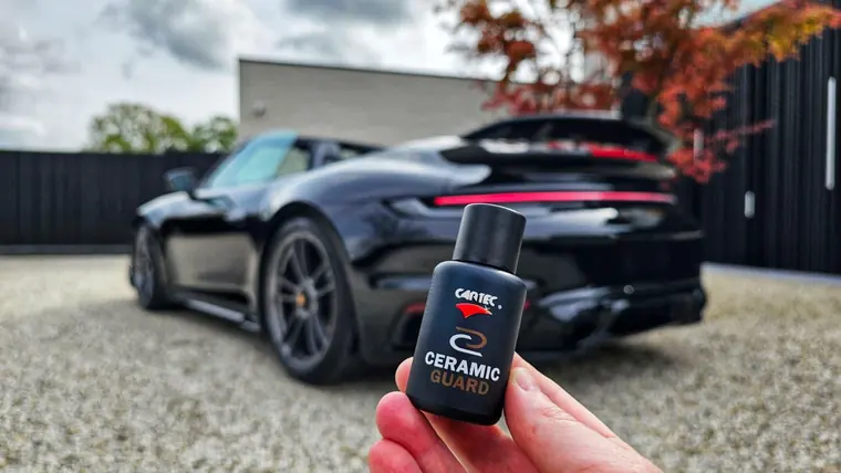 Porsche 911 noire et flacon Cartec Ceramic Guard au premier plan