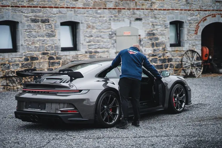 Porsche 911 grise devant un atelier, vue arri&egrave;re avec intervenant