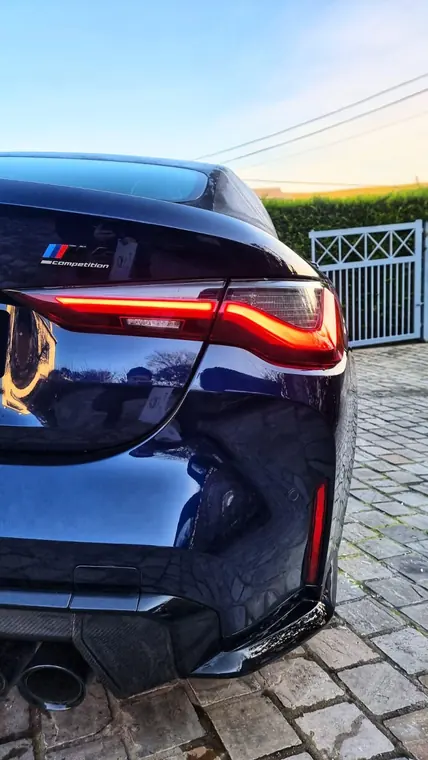 Partie arri&egrave;re d&rsquo;une BMW bleue sur pav&eacute;s