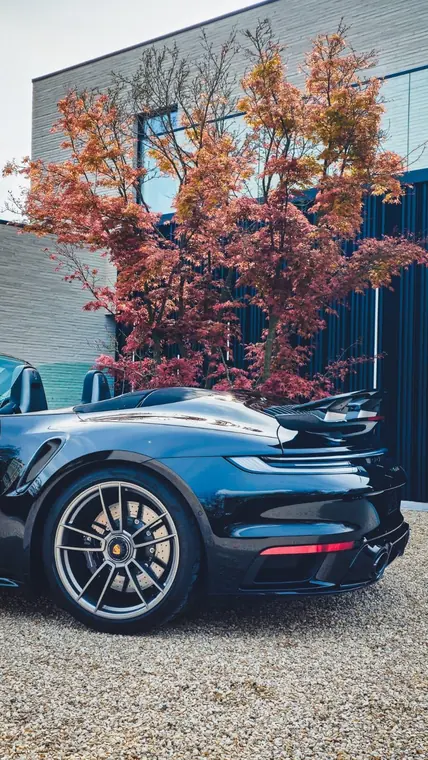 Porsche 911 noire, vue arri&egrave;re trois quarts en ext&eacute;rieur