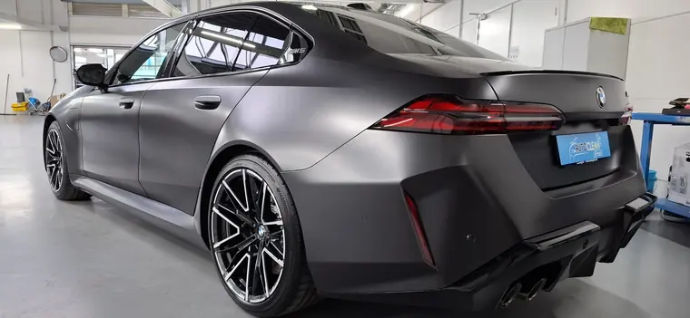 BMW M5 gris mat, vue arri&egrave;re trois quarts en atelier