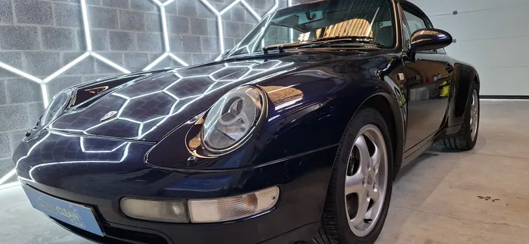 Porsche 911 classique bleu fonc&eacute; dans un atelier de detailing