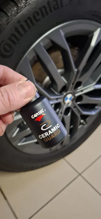 Flacon Cartec Ceramic Guard devant une jante BMW