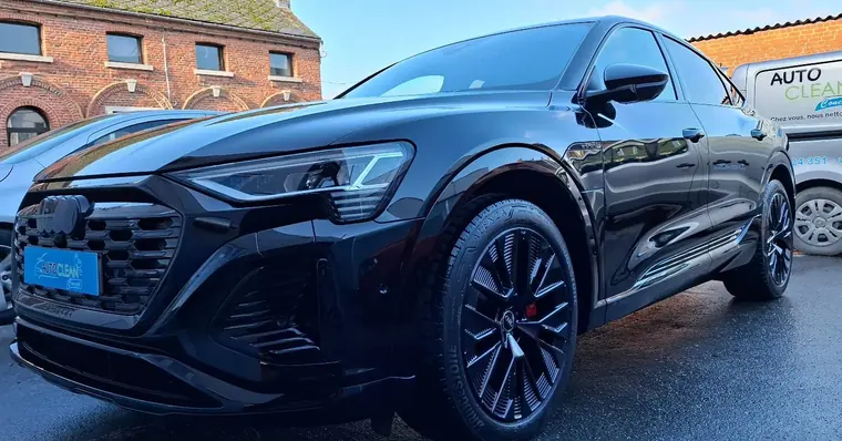 Audi sportive noire, vue avant devant un atelier