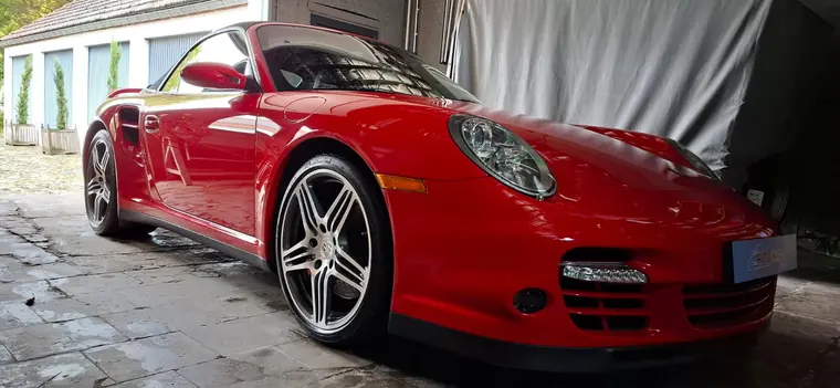 Porsche 911 rouge photographi&eacute;e dans un atelier
