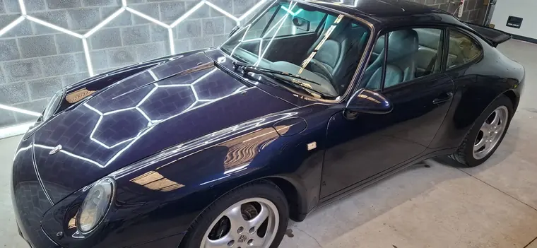 Porsche 911 classique bleu fonc&eacute; sous &eacute;clairage hexagonal