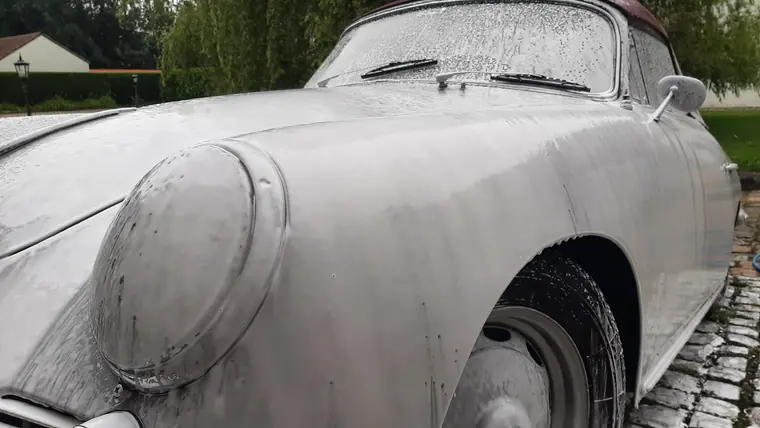Face avant d&rsquo;une Porsche ancienne sous mousse de nettoyage