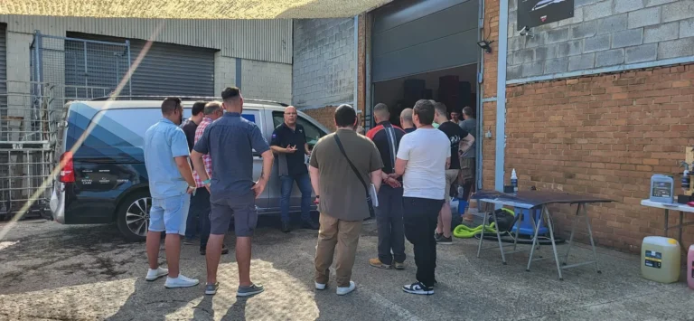 Visiteurs r&eacute;unis autour d&rsquo;un v&eacute;hicule dans la cour &mdash; d&eacute;monstration gratuite des produits Cartec &agrave; l&rsquo;entrep&ocirc;t, avril 2025