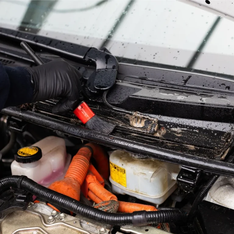 Nettoyage d’un compartiment moteur avec un pinceau et un produit Cartec