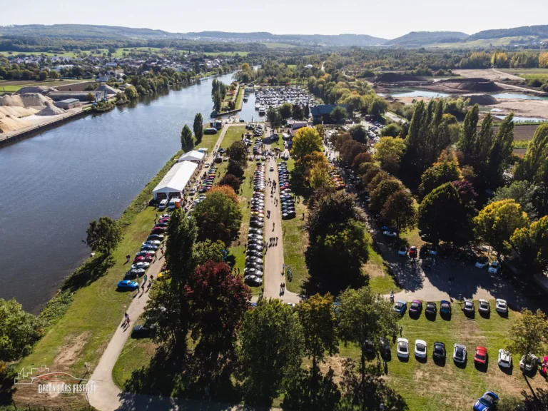 Vue aérienne du Dream Car Festival au Luxembourg : alignements de voitures et chapiteaux