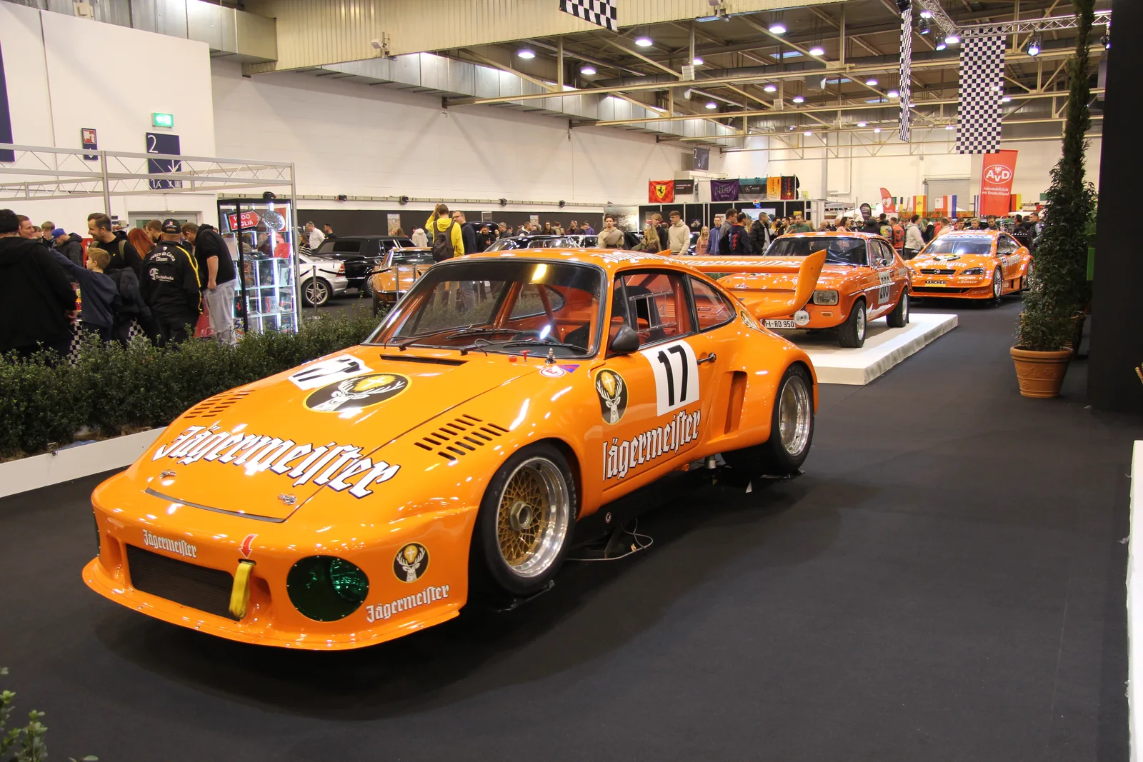 Porsche de compétition orange exposée dans les halls — Essen Motor Show 2023