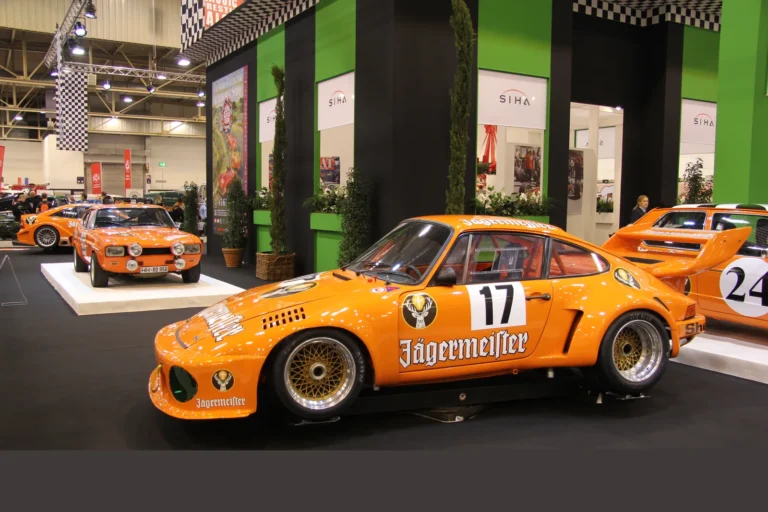 Porsche de compétition orange vue de profil — Essen Motor Show 2023