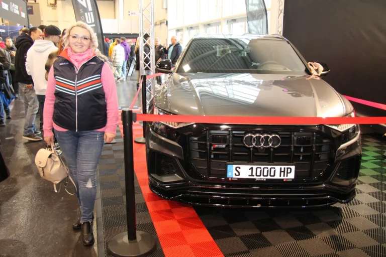 Visiteuse devant un coupé sportif noir — Essen Motor Show 2023