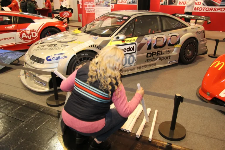 Visiteuse devant une voiture de compétition — Essen Motor Show 2023