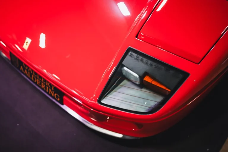 D&eacute;tail du phare d&rsquo;une voiture rouge &agrave; R&eacute;tromobile Paris 2025