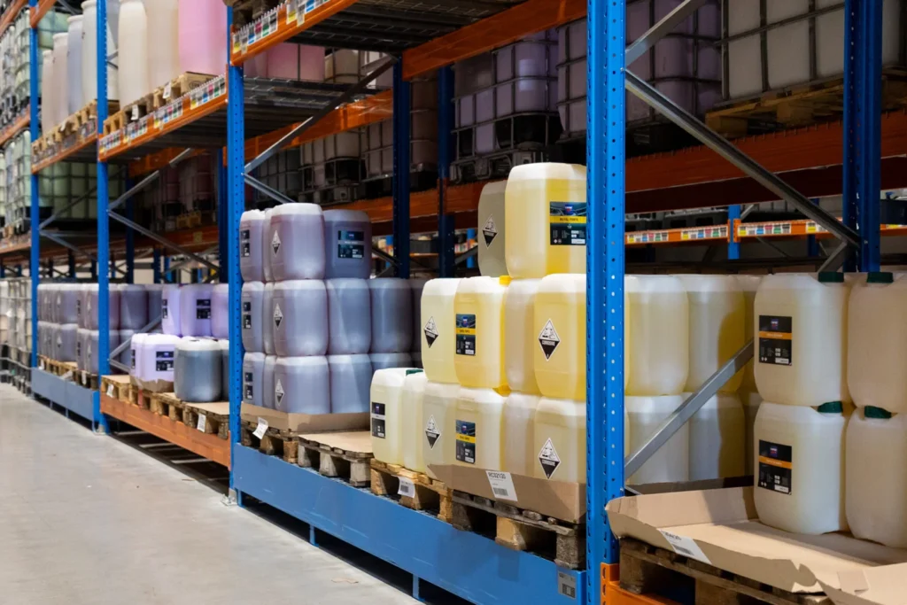 Bidons de produits Cartec align&eacute;s devant les rayonnages