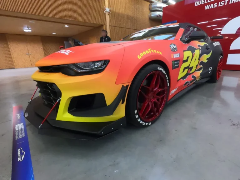 Voiture de comp&eacute;tition aux couleurs rouge et jaune &mdash; International Motor Show Luxembourg 2025