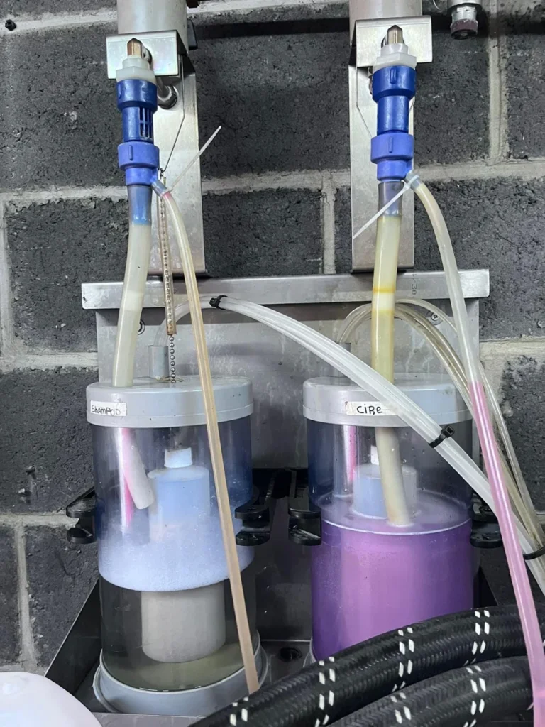 Doseurs de shampooing et de cire dans le local technique du car wash