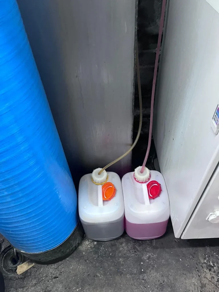 Bidons et tuyaux d&rsquo;aspiration pour l&rsquo;alimentation de l&rsquo;installation de lavage