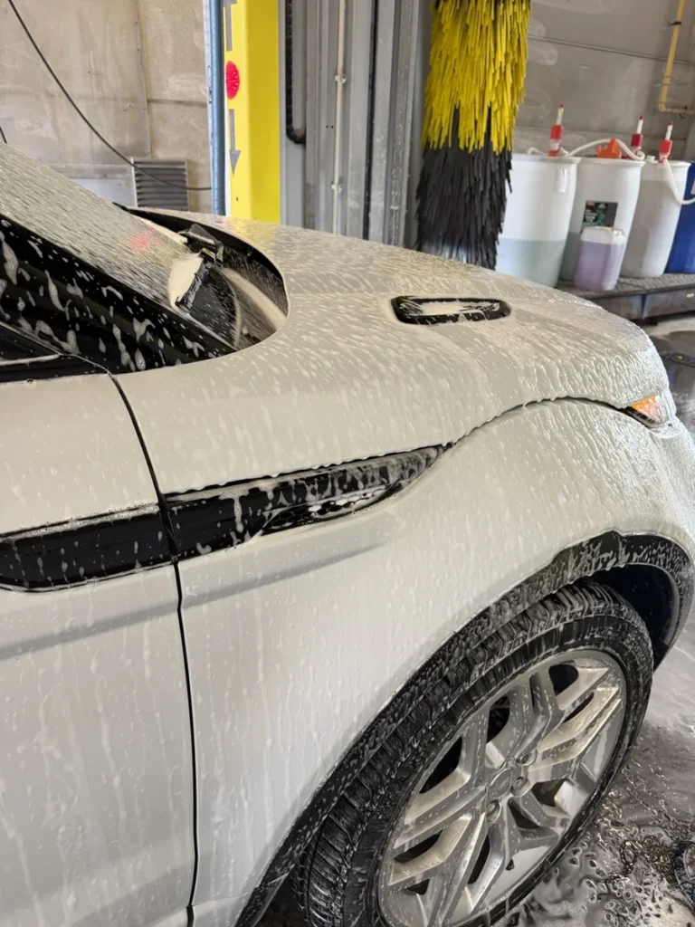 Range Rover Evoque cabriolet blanc : mousse sur le capot et le flanc avant au portique