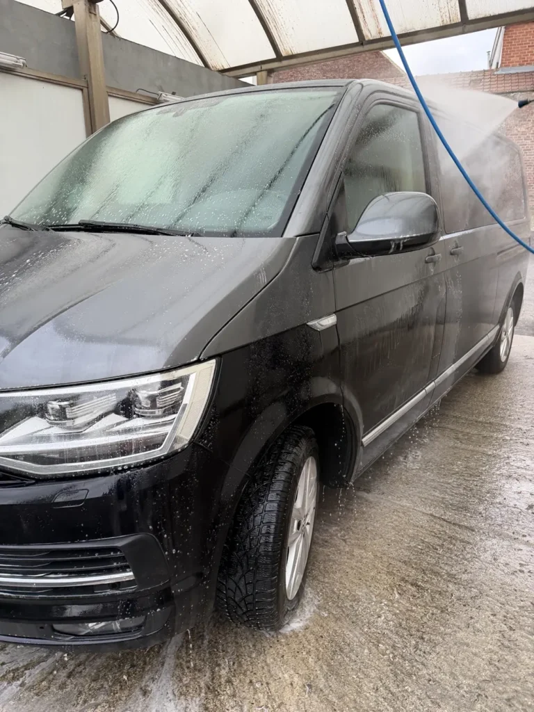 Rin&ccedil;age haute pression d&rsquo;un Volkswagen noir dans une piste de self-wash