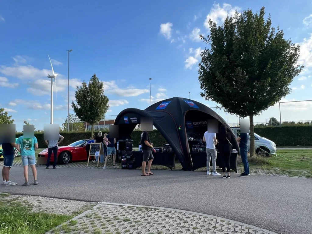 Visiteurs autour du stand Cartec et de la Ferrari California rouge