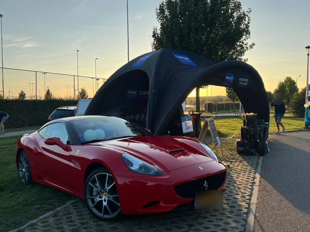 Ferrari California rouge devant le stand gonflable Cartec