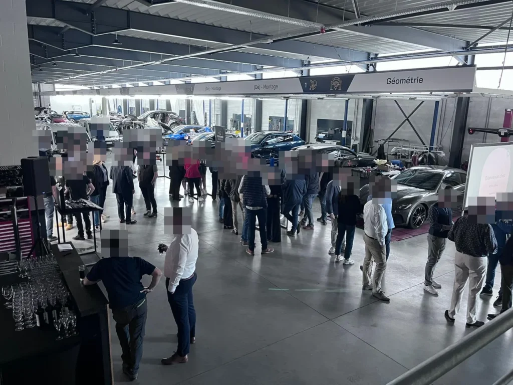 Participants r&eacute;unis dans l&rsquo;atelier Wondercar Steveny &agrave; Namur lors de l&rsquo;inauguration, visages masqu&eacute;s
